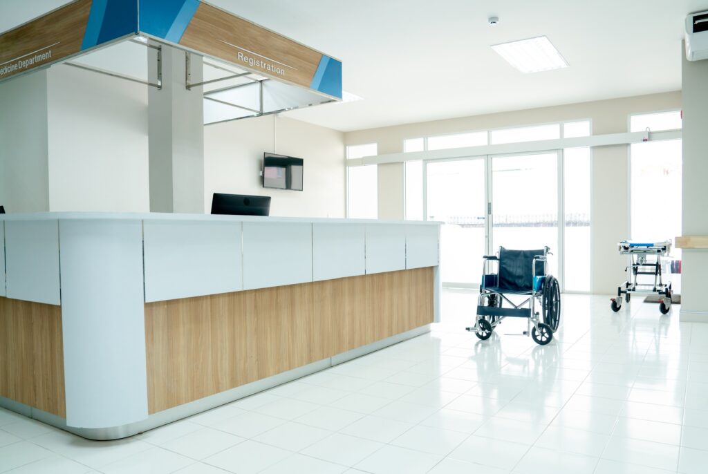 Empty room in area of reception or registration counter in hospital with wheelchair or mobilebed